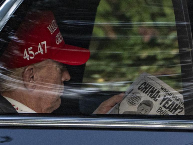 US President Donald Trump, who was seen reading the New York Post, touted an "economic revolution". (AP PHOTO)